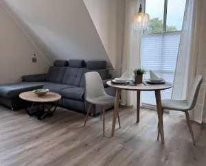 Das gemütliche Sofa lädt um Kuscheln ein, der Tisch ist ideal zum Kartenspielen oder Essen. Ein Küchentisch ist zusätlich vorhanden. Rechts die Türen zum Balkon, wo der Blick richtung Osten Morgensonne verspricht.