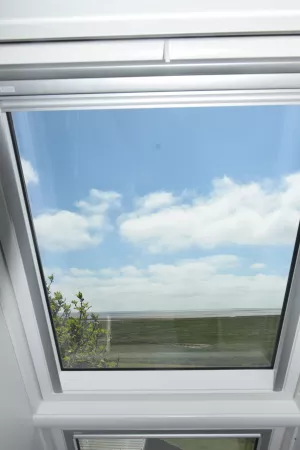 Aus dem Dachfenster auf das Meer und in den Himmel blicken. Gemütlich vor dem Fenster sitzen und den Blick nach Süden mit Wolken und Meer genießen.