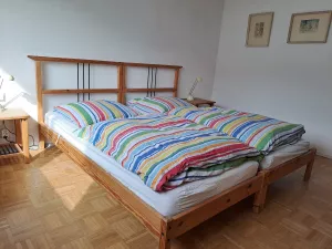 Schlafzimmer mit 2 Einzelbetten die zu einem Doppelbett zusammengeschoben werden können. Es gibt 2 Nachttischchen, 1 Kleiderschrank, 2 Stühle, 1 Spiegel